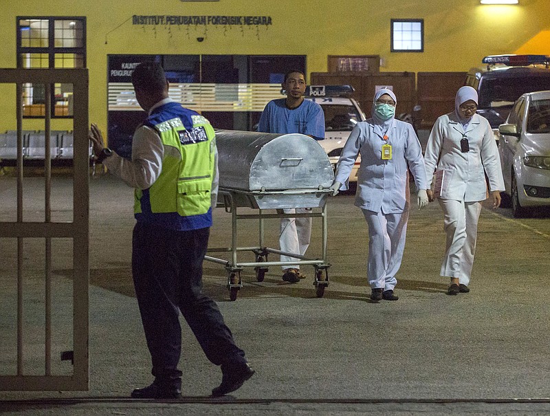 
              Medical staff carry a metallic bed which is used for transporting dead bodies out of the forensic department at Kuala Lumpur Hospital in Kuala Lumpur, Malaysia, Sunday, Feb. 19, 2017. Speculation that the estranged half brother of the North Korean leader was killed by two young female agents at the busy Kuala Lumpur airport last week left even the most seasoned toxicology sleuths shaking their heads. (AP Photo/Alexandra Radu)
            