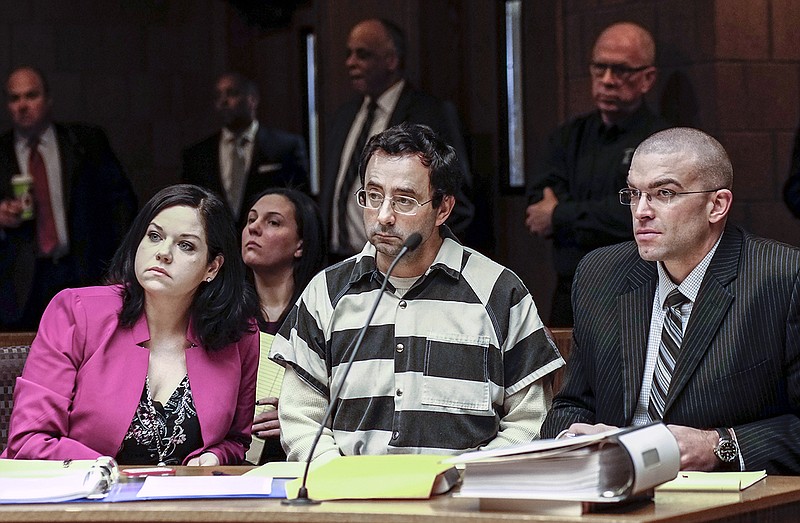 
              Dr. Larry Nassar, center, and his attorneys, Shannon Smith and Matt Newburg, listen to Judge Donald Allen Jr. rule that Nassar, a former Michigan State University and USA Gymnastics sports doctor, should stand trial on sexual assault charges during a hearing, Friday, Feb. 17, 2017, in Lansing, Mich. Nassar is accused of assaulting a girl from the age of 6 until the girl was 12 at his home in Holt, Mich. He's pleaded not guilty. (Robert Killips/Lansing State Journal via AP)
            