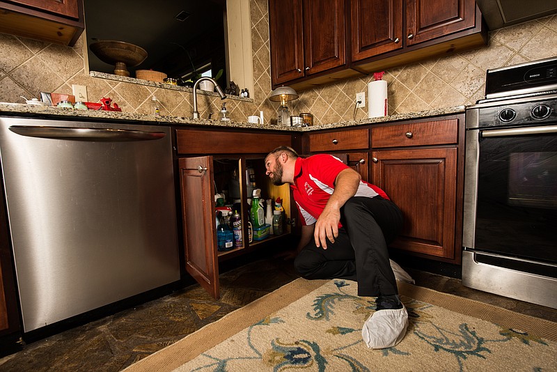 Alex Herrick inspects potential plumbing issues in a residential home.