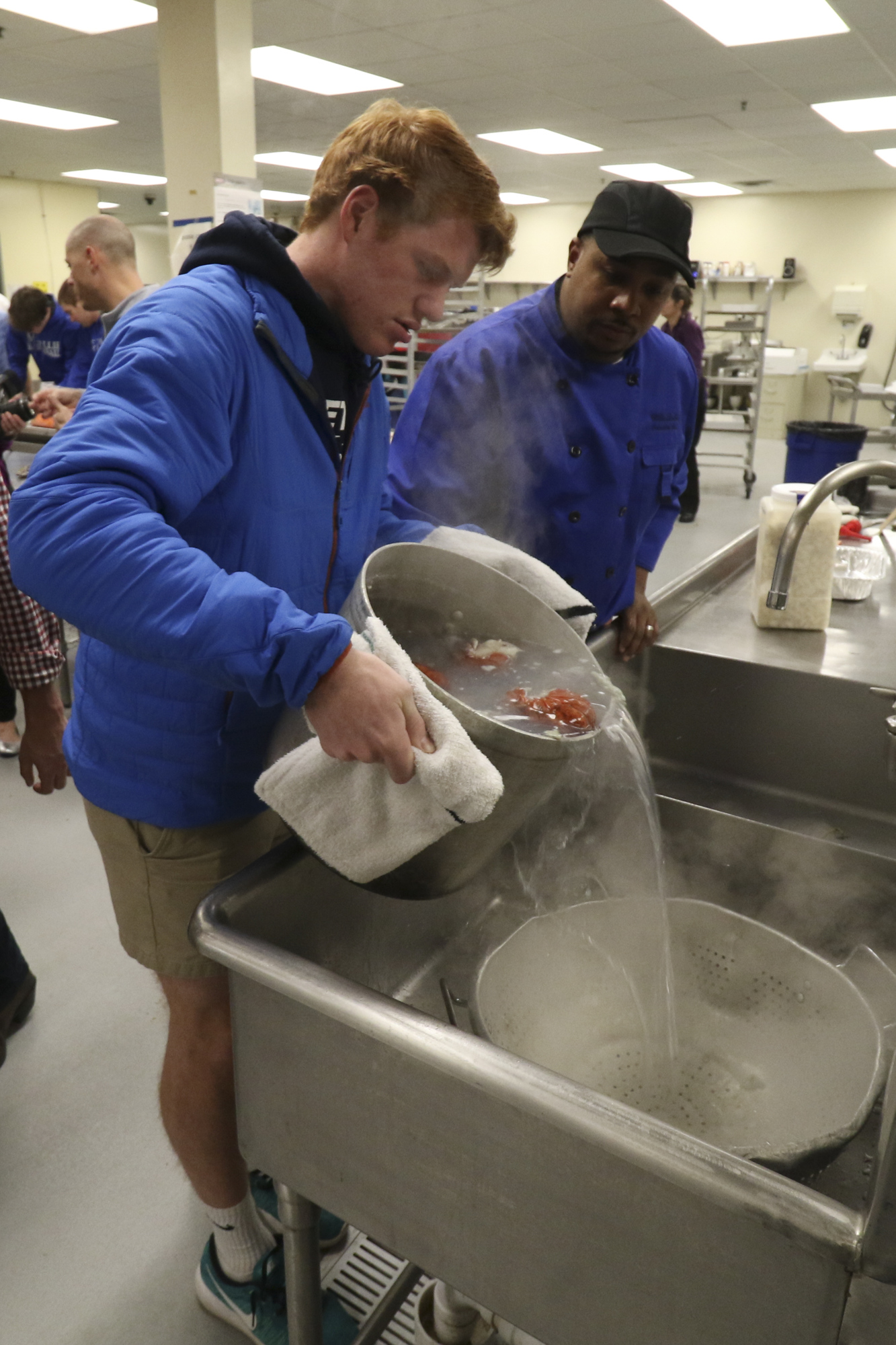 McCallie School Executive Chef Willie Dabbs supervises senior Cameron Langsett as he drains lobster in preparation to making Lobster Creamy Herbed Pasta.