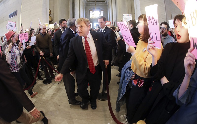 
              FILE - In this Monday, Jan. 30, 2017, file photo, Rep. Dennis Powers, R-Jacksboro, center, walks between rows of protesters as he makes his way to the House chamber for Gov. Bill Haslam's annual State of the State address to a joint convention of the Tennessee General Assembly, in Nashville, Tenn. Protests around the state Capitol in Nashville have some Republicans calling for a crackdown on demonstrators and for resurrecting more stringent security requirements for entering the legislative office complex. Democrats are pushing back against those calls, arguing that access to the legislators shouldn’t be curtailed only because many of the protesters oppose the policies of Republican President Donald Trump on issues including immigration, race, abortion and LGBT rights. (AP Photo/Mark Humphrey, File)
            