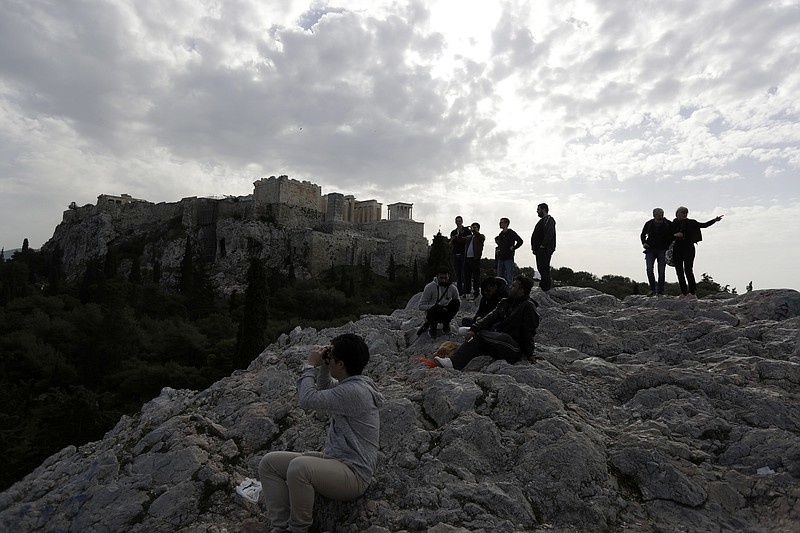 
              Tourists stand on a hill under ancient Acropolis hill during a 24-hour strike by archaeological guards demanding unpaid wages and the recruitment of additional employees in Athens, Monday, Feb. 20, 2017. Greece has been struggling for months to conclude negotiations with its creditors on spending cuts and reforms demanded by European creditors and the International Monetary Fund as part of its third bailout program. (AP Photo/Thanassis Stavrakis)
            