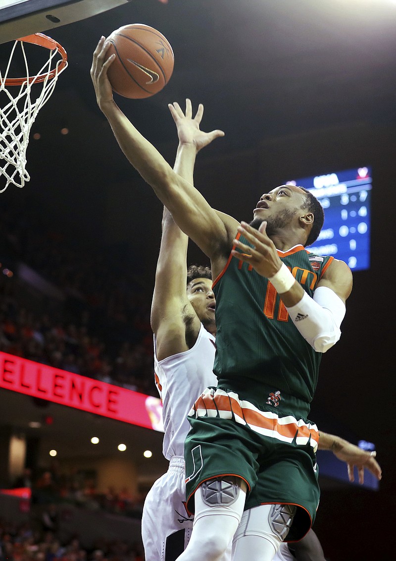 
              Miami guard Bruce Brown (11) shoots over Virginia forward Isaiah Wilkins (21) during the first half of an NCAA college basketball game Monday, Feb. 20, 2017, in Charlottesville, Va. (AP Photo/Ryan M. Kelly)
            