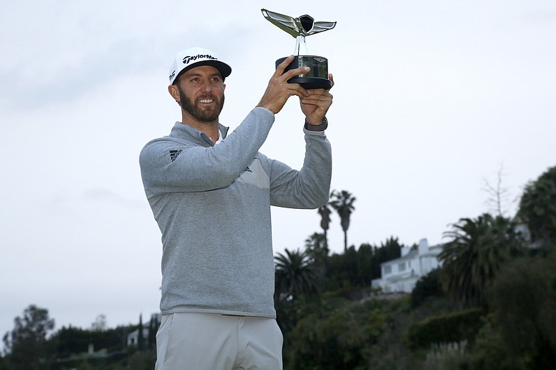 
              Dustin Johnson poses with his trophy on the 18th green after winning the Genesis Open golf tournament at Riviera Country Club on Sunday, Feb. 19, 2017, in the Pacific Palisades area of Los Angeles. (AP Photo/Ryan Kang)
            