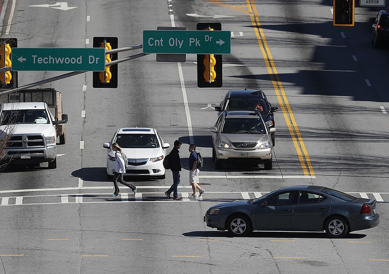 In this Feb. 15, 2017, file photo, pedestrians and cars travel along a busy section of North Avenue near the Georgia Tech campus in Atlanta. North Avenue is being eyed as a real-world proving ground for self-driving vehicles, one of several communities nationwide vying to be test sites for the emerging technology. (AP Photo/John Bazemore)

