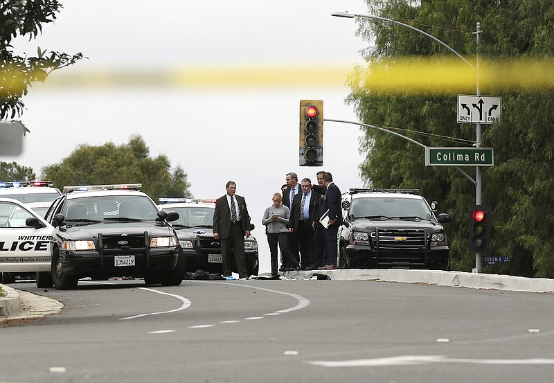 
              Authorities investigate the scene after a deadly shooting in Whitter, Calif., Monday, Feb. 20, 2017. A California police officer was killed and another wounded in a shooting Monday while they were trying to help a man who had been in a traffic accident in Whittier, officials said. (Katie Falkenberg/Los Angeles Times via AP)
            