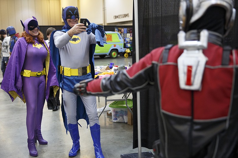 Amanda Tolbert, left, and Eddie Curtis, dressed as Batgirl and Batman, photograph Scott Lang, dressed as Antman, at last year's Con Nooga at the Chattanooga Convention Center.