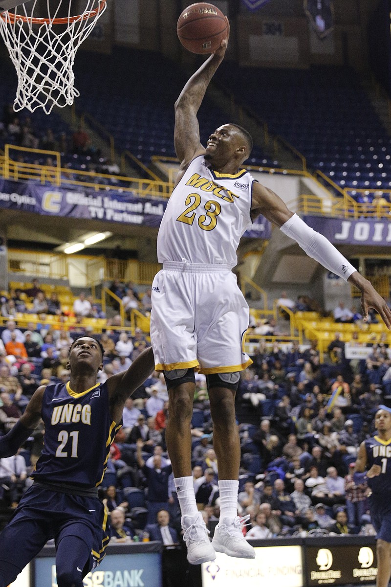 UTC forward Tre' McLean goes for a dunk over UNCG forward James Dickey III during the Mocs' home basketball game against the UNCG Spartans at McKenzie Arena on Thursday, Feb. 2, 2017, in Chattanooga, Tenn.