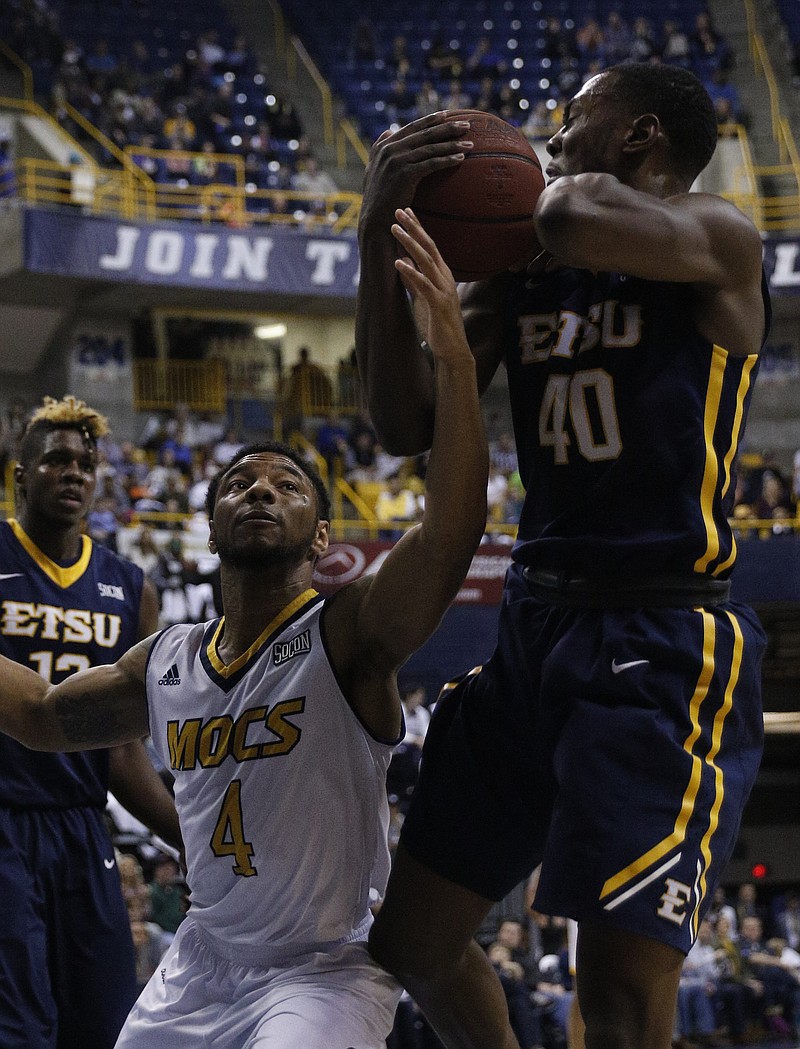 ETSU foward Tevin Glass rebounds ahead of UTC guard Johnathan Burroughs-Cook during the Mocs' basketball game against the ETSU Buccaneers at McKenzie Arena on Saturday, Feb. 18, 2017, in Chattanooga, Tenn. UTC fell to 10-5 in the SoCon following their 65-51 loss to ETSU.