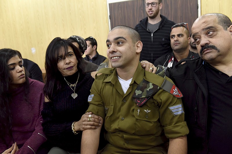 
              FILE -- In this January 24, 2017 file photo, Israeli soldier Sgt. Elor Azaria attends a sentencing hearing in the military court surrounded by his family, in Tel Aviv, Israel. The Israeli army said a military court on Tuesday, Feb, 21, 2017,  will sentence a soldier convicted of manslaughter for fatally shooting a wounded Palestinian assailant. Azaria faces a maximum sentence of 20 years, though analysts expect him to receive less than that. (Debbie Hill, Pool via AP, File)
            