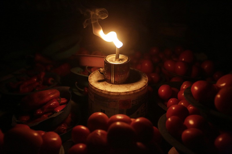 
              In this photo taken on Monday Feb. 20, 2017, vegetable sellers ply their wares by the light of locally-made lanterns in Lagos, Nigeria. In Nigeria, for the cost of powering a small generator for two hours, Dutch company Lumos offer enough solar power to light a house, cool a room with a fan and charge cell phones for about eight hours. For a country without a secure supply of electricity where people are dependent on candles, batteries, kerosene and fuel for generators, Lumos was surprised they spend more on power than solar options. (AP Photo/Sunday Alamba)
            