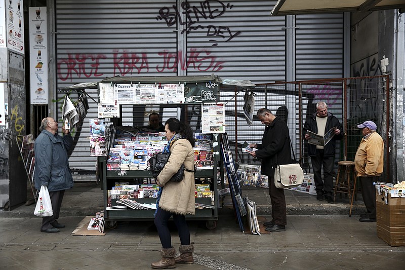 
              People read newspapers around a kiosk in Athens, Tuesday, Feb. 21, 2017. Greece and its European creditors agreed Monday to resume talks on what economic reforms the country must make next in order to get the money it needs to avoid bankruptcy and a potential exit from the euro this summer. (AP Photo/Yorgos Karahalis)
            