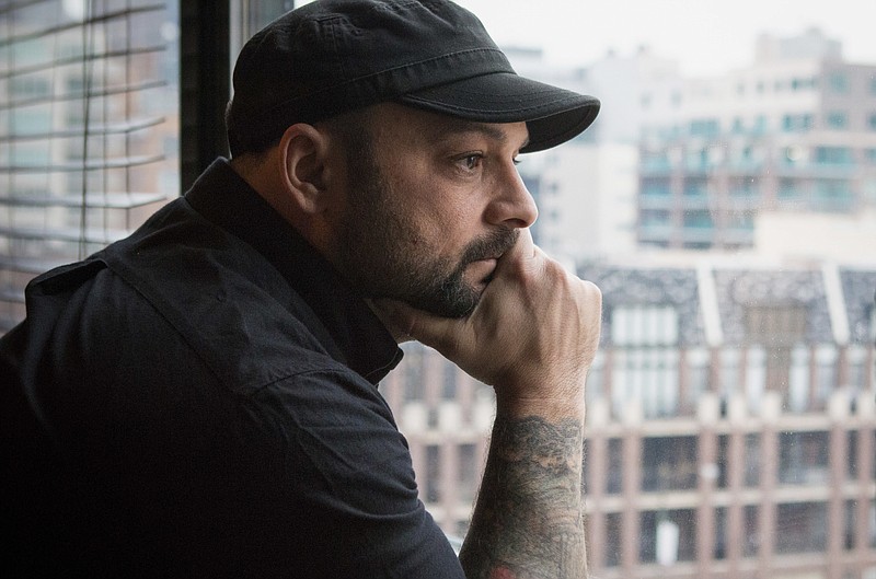 In this Jan. 9, 2017, photo, Christian Picciolini, founder of the group Life After Hate, poses for a photograph in his Chicago home. Picciolini, a former skinhead, is an activist combatting what many see as a surge in white nationalism across the United States. He's doing it by helping members quit groups including the Ku Klux Klan and skinhead organizations. (AP Photo/Teresa Crawford)