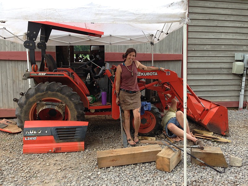 Crabtree Farms Executive Director Sara McIntyre works on the farm tractor, AKA "Grandpa."