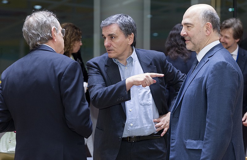 
              Italian Minister Economy & Finance Pier Carlo Padoan, left, is talking with the Greek Finance Minister Euclid Tsakalotos, Center, and the EU Economic and Financial Affairs, Taxation and Customs Commissioner Pierre Moscovici prior to a round table meeting of Eurogroup finance ministers at the EU Council building in Brussels on Monday, Feb. 20, 2017. The eurozone's 19 finance ministers will be looking to defuse the risk of another Greek crisis as they try to agree Monday on what reforms Greece must still take to qualify for more loans. (AP Photo/Thierry Monasse)
            