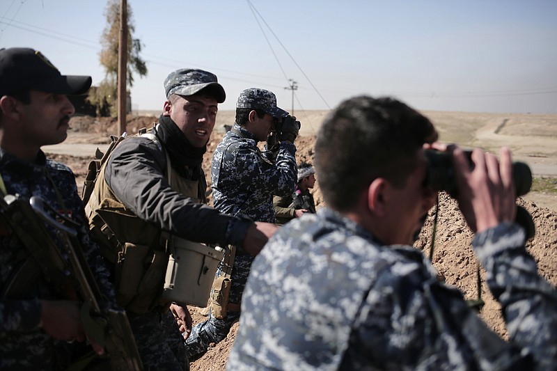 
              Federal police officers look towards Islamic State group territory as civilians flee the area, in the town of Abu Saif, Iraq, Tuesday, Feb. 21, 2017. A military spokesman says Iraqi forces are consolidating their gains south of Mosul ahead of moving deeper into the city's Islamic State-held western half. The spokesman of the Joint Military Operation Command, Brig. Gen. Yahya Rasool, told The Associated Press that nearly 123 square kilometers -- about 47 square miles -- have been taken south of Mosul since the new push started on Sunday. (AP Photo/Bram Janssen)
            