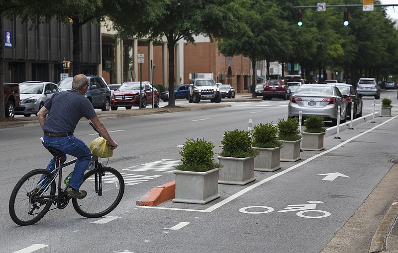 A cyclist rides outside of the bicycle lane on Broad Street on Friday, May 6, 2016, in Chattanooga, Tenn.