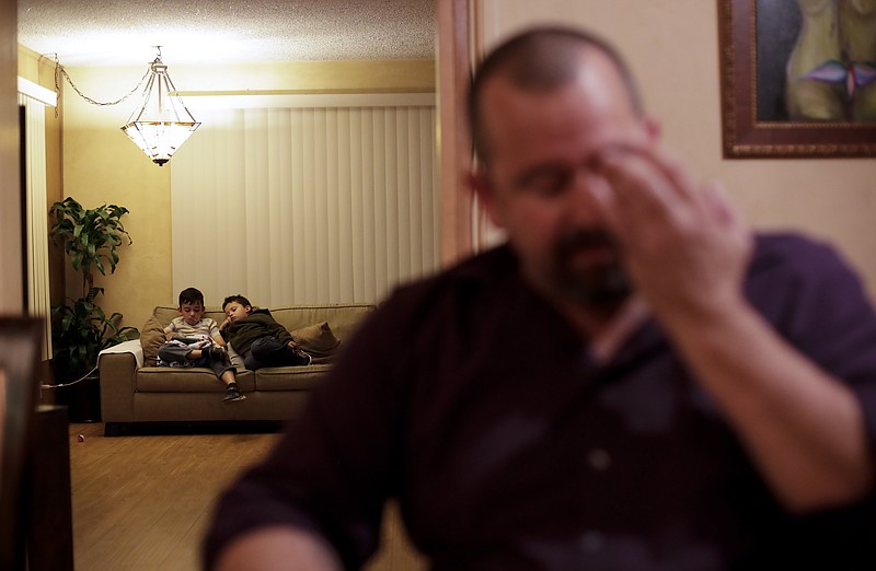 
              Mr. Lane, who did not give his first name, sits at the dining room table as his two children watch a movie in their home Wednesday, Feb. 22, 2017, in San Diego. The Lane family has been on edge since President Donald Trump took office. The mother, a Mexican who is in the country illegally, now carries her birth and marriage certificates and other documents wherever she goes. Around the country, Trump's efforts to crack down on the estimated 11 million immigrants living illegally in the U.S. have spread fear and anxiety and led many people to brace for arrest and to change up their daily routines in hopes of not getting caught. (AP Photo/Gregory Bull)
            