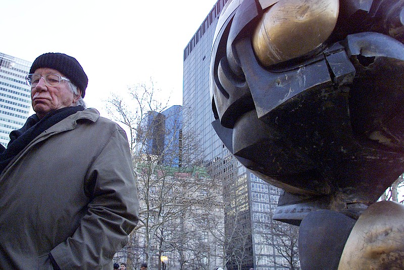 
              FILE - In this file photo dated Monday, March 11, 2002, German artist Fritz Koenig stands next to his bronze sculpture "The Sphere" after a dedication ceremony in New York.  Koenig who's artwork "The Sphere" became a symbol of resilience after the 9/11 attacks in New York, died Wednesday Feb. 22, 2017 aged 92, according to news reports and Bavaria state's Ministry of Culture. (AP Photo/Beth A. Keiser, FILE)
            