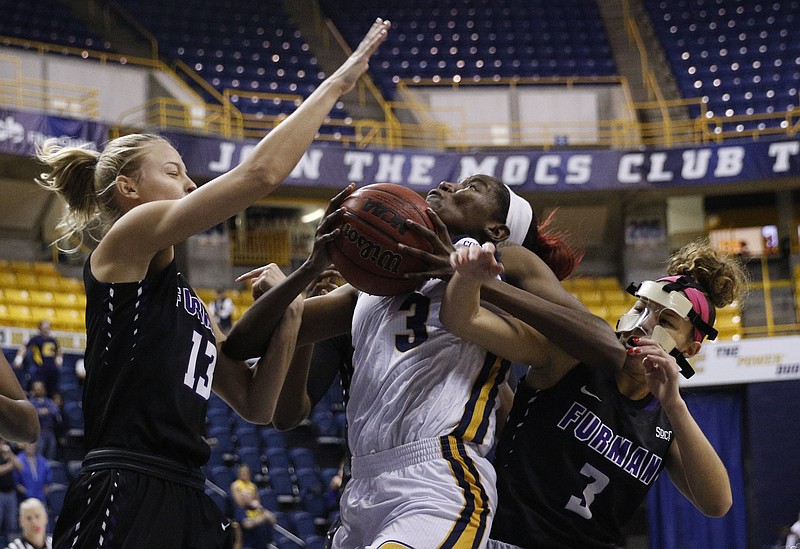 UTC forward Jasmine Joyner, center, gets caught between Furman's Kaitlyn Duncan, left, and Stephania Oramas during the Mocs' 66-43 win Thursday night at McKenzie Arena.