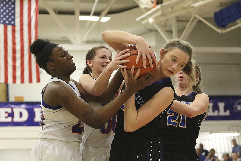 Staff Photo by Dan Henry / The Chattanooga Times Free Press- 2/24/17. Red Bank's Mya Kennebrew (23) and Jasmine Roberts (00) attempt to strip the ball from Sweetwater's Mikalee Martin (20) as teammate Shelby Watson (21) joins in during their matchup at the Lions' home court on Friday, February 24, 2017. Red Bank won over Sweetwater with a final score of 67-47.