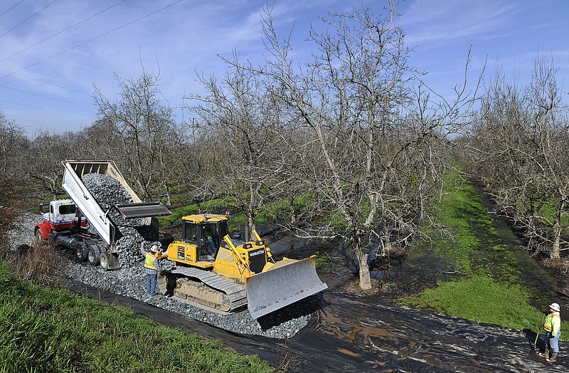 
              FILE - In this Feb. 14, 2017, file photo, crews from Teichert Construction, the California Department of Water Resources and MBK Engineers shore up a section of levee along the Sacramento River in Verona, Calif. Billions of dollars of flood projects in the past two decades have eased fears of levee breaks in Sacramento and other Central Valley cities. But flood experts say levees protecting farms and farm towns also need billions of dollars in maintenance and upgrades. (Chris Kaufman/The Appeal-Democrat via AP, File)
            