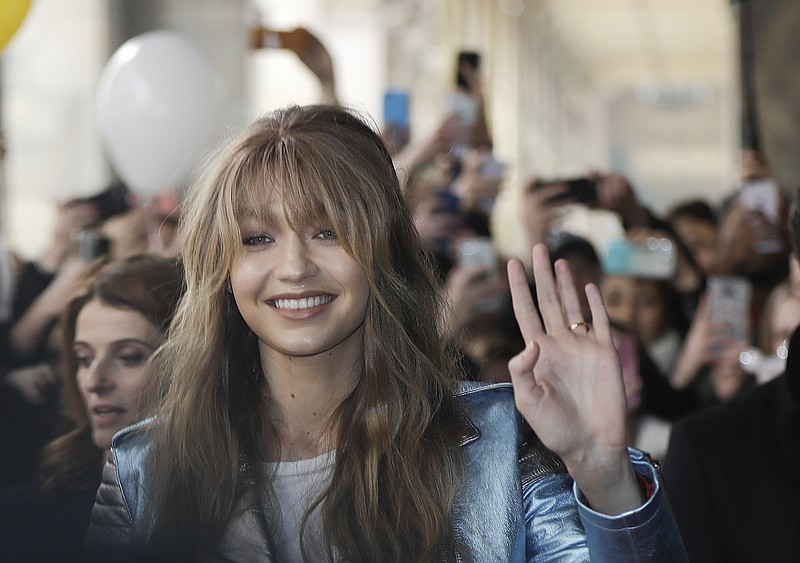 
              Model Gigi Hadid waves as she arrives to attend a presentation for Tommy Hilfiger women's Fall-Winter 2017-18 collection, in Milan, Italy, Friday, Feb. 24, 2017. (AP Photo/Luca Bruno).
            