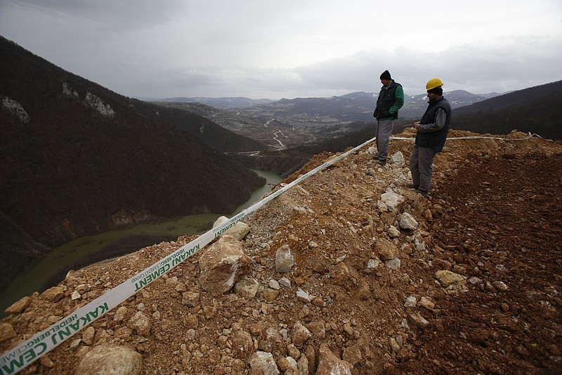 
              Workers survey damage after a landslide near the Bosnian town of Kakanj located 50 kms north of Sarajevo on Friday, Feb. 24, 2017. More than 150 people have been forced to evacuate their homes in central Bosnia due to a major landslide at an open pit coal mine that threatened to bury their villages. (AP Photo/Amel Emric)
            