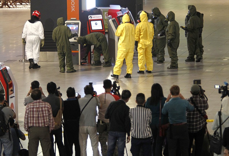 
              Hazmat crews investigate the check in kiosk machines at Kuala Lumpur International Airport 2 in Sepang, Malaysia on Sunday, Feb. 26, 2017. Malaysian police ordered a sweep of Kuala Lumpur airport for toxic chemicals and other hazardous substances following the killing of Kim Jong Nam. (AP Photo/Daniel Chan)
            