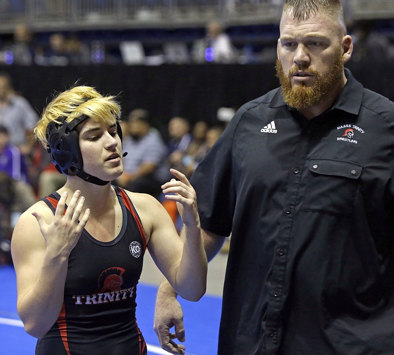 Mack Beggs, left, a transgender wrestler from Euless Trinity High School, stands with his coach Travis Clark during a quarterfinal match against Mya Engert, of Amarillo Tascosa, during the State Wrestling Tournament, Friday, Feb. 24, 2017, in Cypress, Texas. Beggs was born a girl and is transitioning to male but wrestles in the girls division. ( Melissa Phillip/Houston Chronicle via AP)

