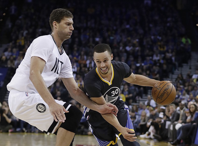 
              Golden State Warriors' Stephen Curry (30) dribbles past Brooklyn Nets' Brook Lopez during the first half of an NBA basketball game Saturday, Feb. 25, 2017, in Oakland, Calif. (AP Photo/Marcio Jose Sanchez)
            