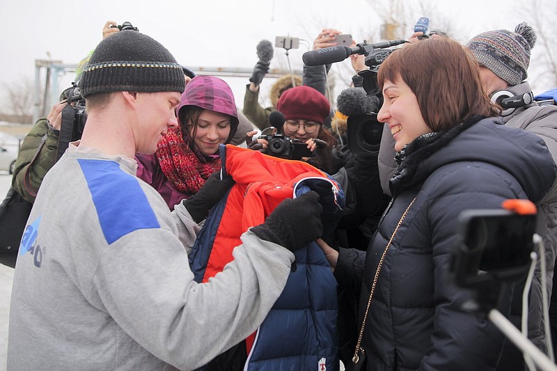
              Russian opposition activist Ildar Dadin, left, receives a parka from his wife Anastasia Zotova, right, upon leaving a prison in Rubtsovsk, 3,400 kilometers ( 2,125 miles ) east of Moscow, Russia, Sunday, Feb. 26, 2017. Russia released Sunday the convicted opposition activist who has said he was tortured in prison. Dadin was freed from his jail in the remote Altai region in southern Siberia after Russia’s Supreme Court annulled his 2½-year sentence because of procedural violations last week. (AP Photo/Alexei Zweigert)
            