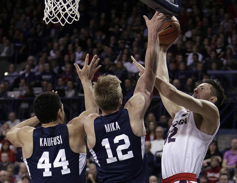 Gonzaga forward Zach Collins, right, shoots against BYU forward Eric Mika (12) and center Corbin Kaufusi (44) during the first half of an NCAA college basketball game in Spokane, Wash., Saturday, Feb. 25, 2017. (AP Photo/Young Kwak)