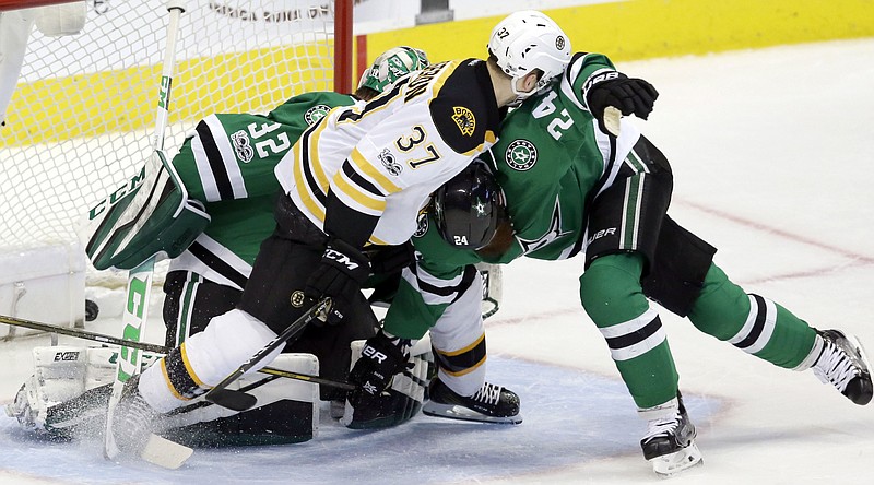 
              Boston Bruins center Patrice Bergeron (37) gets the puck into the net to score a goal against Dallas Stars defenseman Jordie Benn (24) and goalie Kari Lehtonen (32) during the second period of an NHL hockey game in Dallas, Sunday, Feb. 26, 2017. (AP Photo/LM Otero)
            