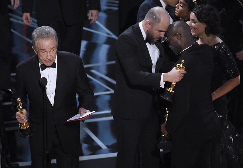 
              Warren Beatty, from left, reveals "Moonlight" as the actual winner of best picture as Jordan Horowitz embraces Barry Jenkins at the Oscars on Sunday, Feb. 26, 2017, at the Dolby Theatre in Los Angeles. (Photo by Chris Pizzello/Invision/AP)
            