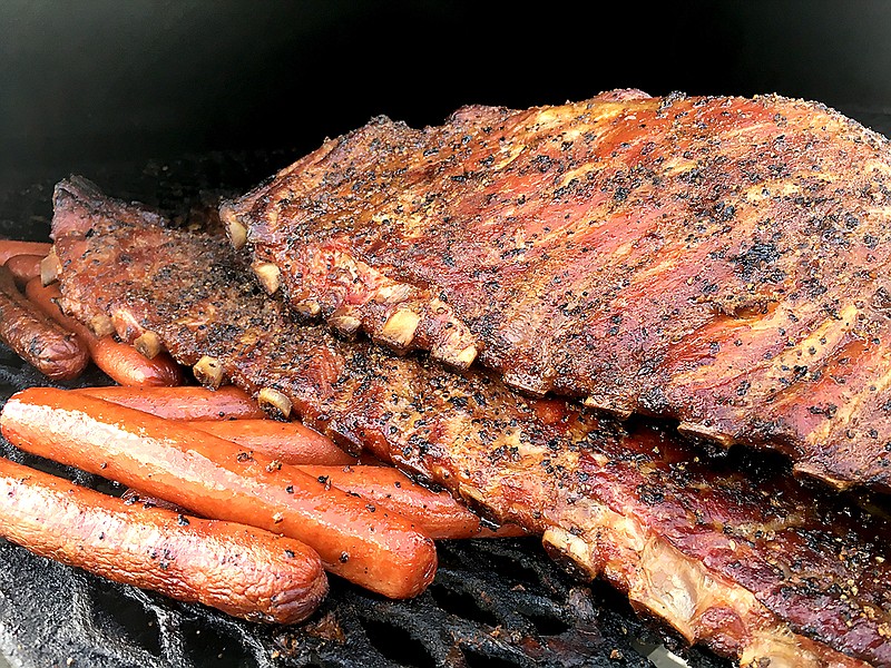 A full rack of ribs grills slowly to perfection at Chatter Box Cafe's permanent location at 1817 Market St. in Chattanooga. Owner Brandon Ellis spends his morning chopping wood to prepare his smoker for a full day of grilling. A rack this size is currently priced at $25. (Staff Photo by Matt McClane)