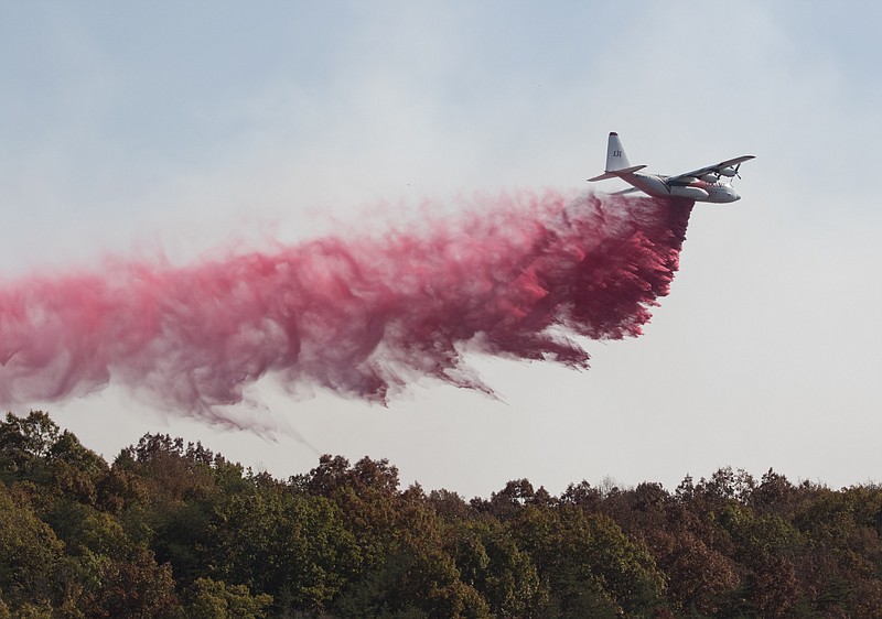 An aircraft from the U.S. Forestry Service drops fire retardant on a wildfire burning along the Flipper Bend area of Signal Mountain on Nov. 9, 2016.