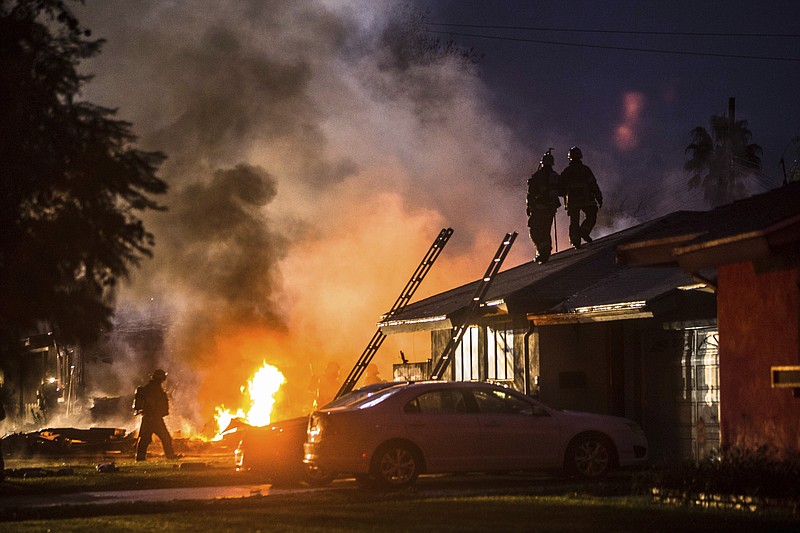 Smoke rises from a fire after a plane crashed in Riverside, Calif., Monday, Feb. 27, 2017. The deadly crash injured several when a small plane collided with two homes Monday shortly after taking off from a nearby airport, officials said. (Watchara Phomicinda/The Press-Enterprise via AP)