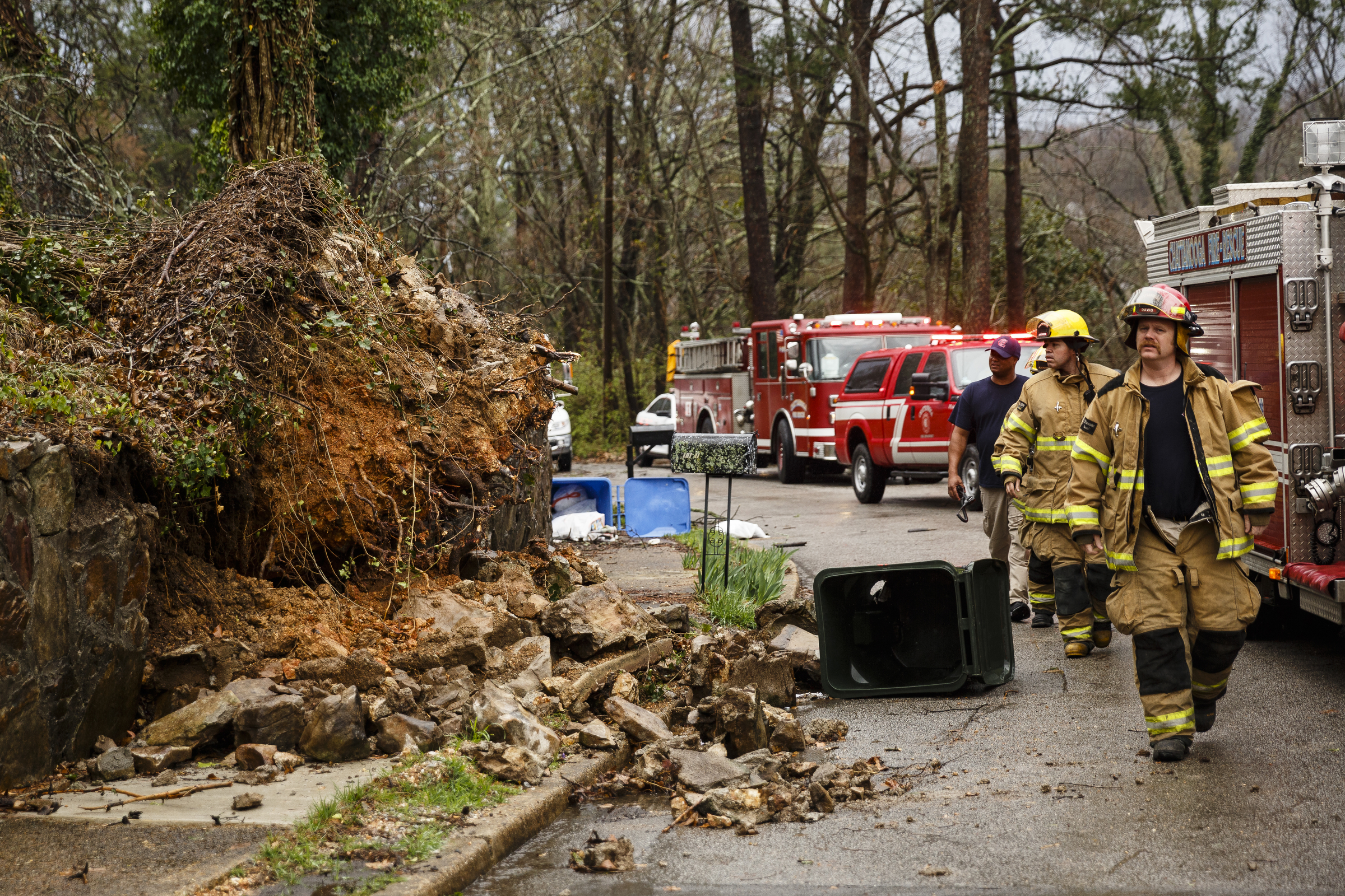 Firefighters walk past a downed tree on Westwood Avenue on Wednesday, March 1, 2017, in Chattanooga, Tenn. Severe storms swept through the region Wednesday afternoon.