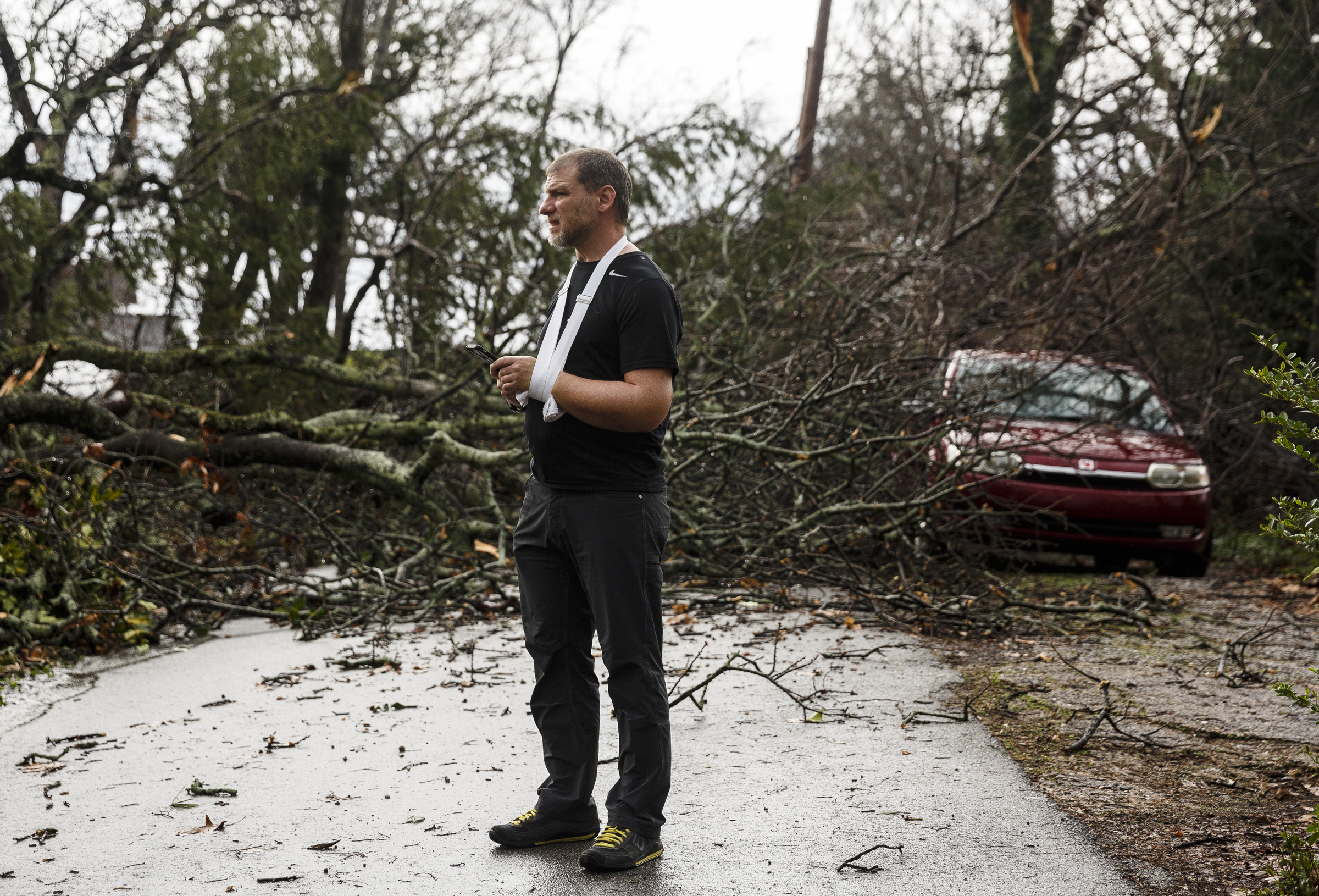 Brett Ratner stands in front of a downed tree in an alley between Westwood Avenue and Highland Drive on Wednesday, March 1, 2017, in Chattanooga, Tenn. Severe storms swept through the region Wednesday afternoon.