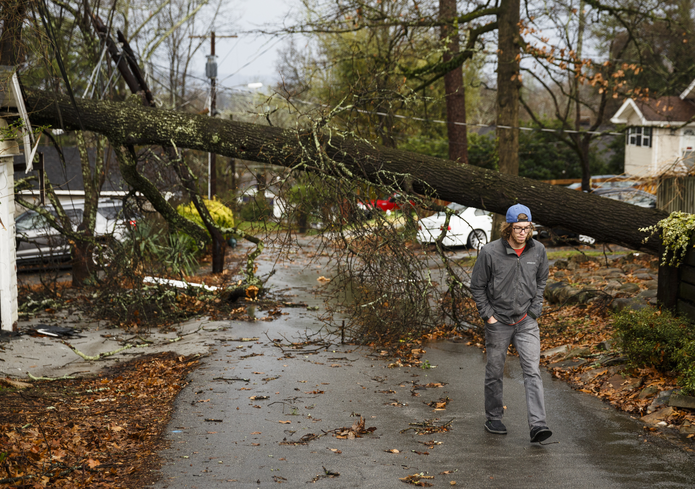 T.J. Maurer walks on an alley between Westwood Avenue and Highland Drive that saw extensive downed trees on Wednesday, March 1, 2017, in Chattanooga, Tenn. Severe storms swept through the region Wednesday afternoon.