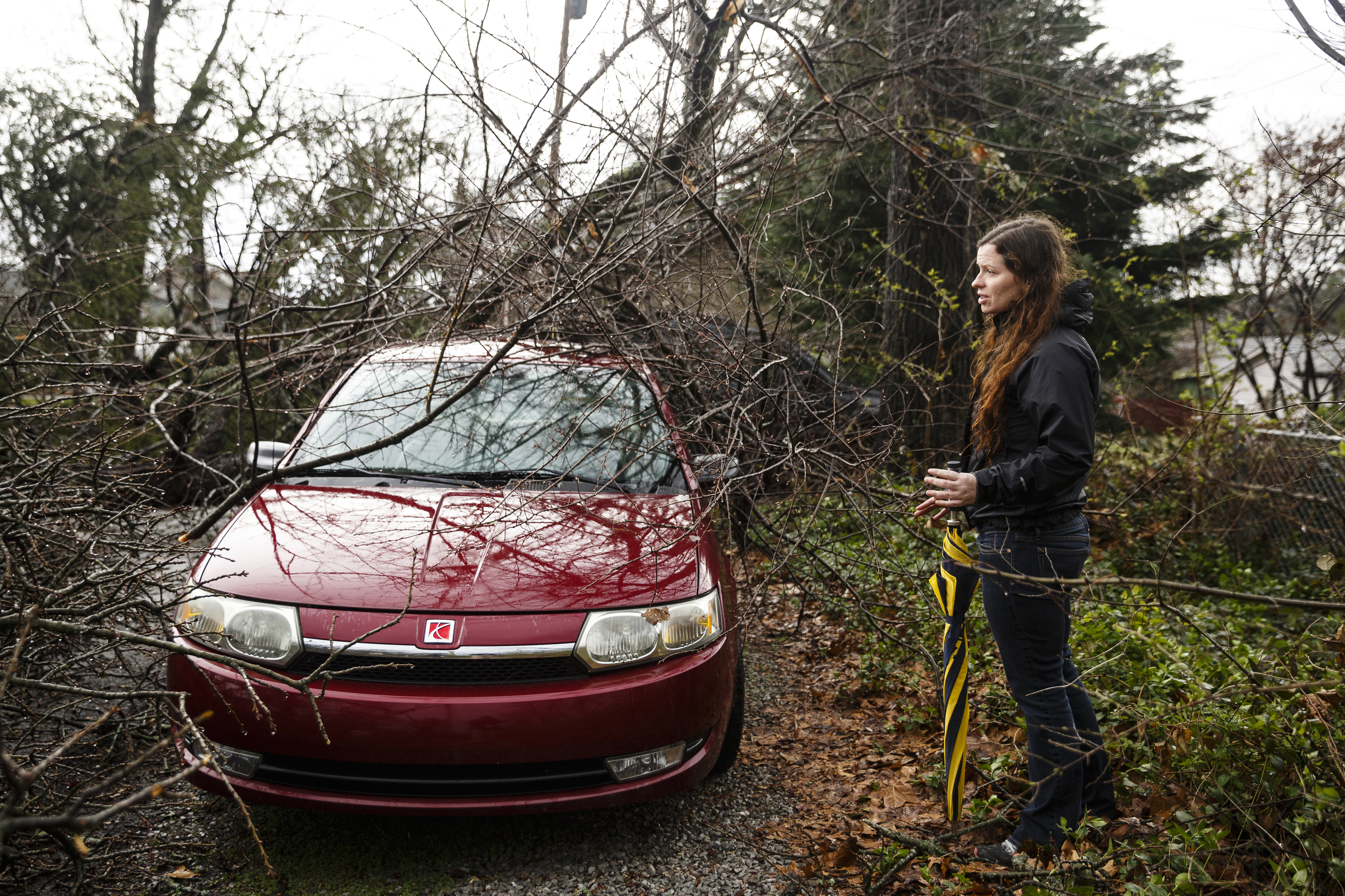 Danielle Mitchell examines a tree that fell on a car parked in an alley between Westwood Avenue and Highland Drive on Wednesday, March 1, 2017, in Chattanooga, Tenn. Severe storms swept through the region Wednesday afternoon.