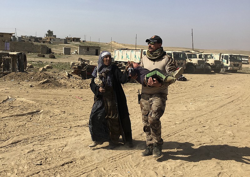 
              An Iraqi Army soldier helps displaced civilians as they flee their homes due to fighting between Iraqi security forces and Islamic State militants, on the western side of Mosul, Iraq, Tuesday, Feb. 28. 2017. Since Iraqi government forces launched the push to take the western half of Mosul from the Islamic State group last week, about 8,000 people have fled from that part of the city and surrounding villages, the U.N. humanitarian aid agency said Tuesday. (AP Photo/Mohammed Saad)
            