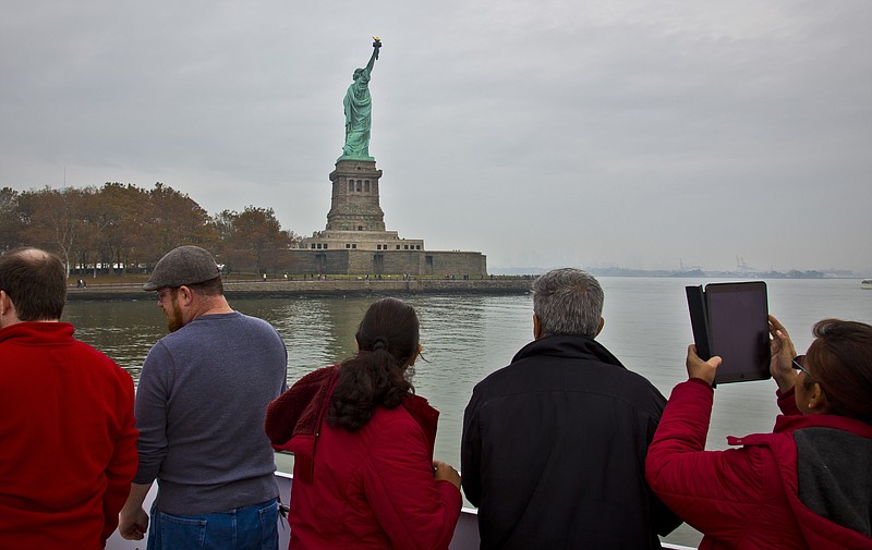 
              FILE - In this Nov. 5, 2015, file photo, visitors view the Statue of Liberty during a ferry ride to Liberty Island in New York. The U.S. Travel Association on Thursday, March 2, 2017, said there are "mounting signs" that the Trump administration's policies are having a "broad chilling effect on demand for international travel to the United States." (AP Photo/Bebeto Matthews, File)
            