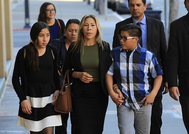 
              With their supporters, Maria Puga, center, arrives with her children to a news conference on Thursday, March 2, 2017, in San Diego, Calif. A federal judge tentatively approved an agreement Thursday for the U.S. government to pay $1 million to the children of  Anastasio Hernandez, a Mexican man who died after being detained by immigration authorities and shot several times with a stun gun. Puga was Hernandez's longtime partner and the mother of their five children. (Eduardo Contreras/The San Diego Union-Tribune via AP)
            