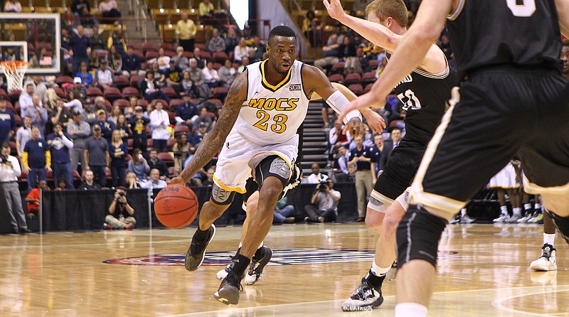 Tre' McLean dribbles past Wofford's Matthew Pegram during the Mocs' 79-67 loss on Saturday. McLean and Justin Tuoyo scored a combined 31 points to bring the Mocs within striking distance of the Terriers, but a 3-pointer by Wofford's Fletcher Magee broke the Mocs' comeback, allowing the Terriers to expand their lead and take the game. 