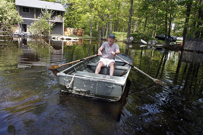 
              FILE - In this May 25, 2011 file photo, Buzz Hoerr rows his boat through floodwaters of Lake Champlain to get to his car in Colchester, Vt. A U.S.-Canadian commission formed to manage boundary water issues between the two countries is going to take five years and spend more than $11 million to look for ways to control flooding on Lake Champlain and the Richelieu River, the waterway that drains the lake north into Quebec. (AP Photo/Toby Talbot, File)
            