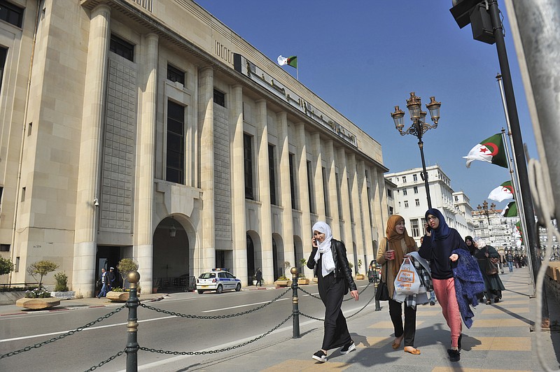 
              In this photo taken on Thursday, March 2, 2017, Algerian women pass by the People's National Assembly building in Algiers, Algeria. Algerian law requires the next parliament to be made up of 30 percent women - but political parties across the spectrum are struggling to come up with enough female candidates to fill the quota. (AP Photo/Anis Belghoul)
            