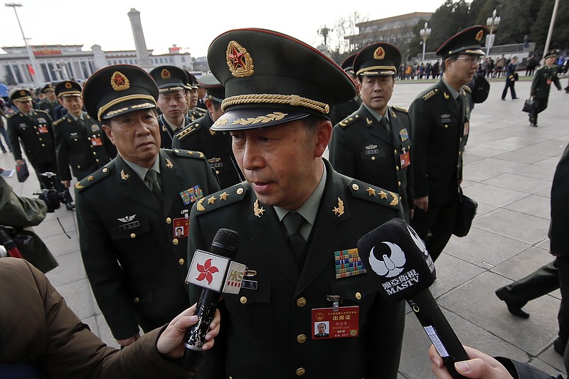 
              A delegate from China's People's Liberation Army (PLA) speaks to journalists as he and his comrades arrive to the Great Hall of the People to attend the opening session of the annual National People's Congress in Beijing, Sunday, March 5, 2017. In a break with past practice, China has provided no exact figure for the defense budget at the opening of its annual legislative session, as National People's Congress spokeswoman Fu Ying on Saturday told reporters the budget would increase by about 7 percent over last year. (AP Photo/Andy Wong)
            