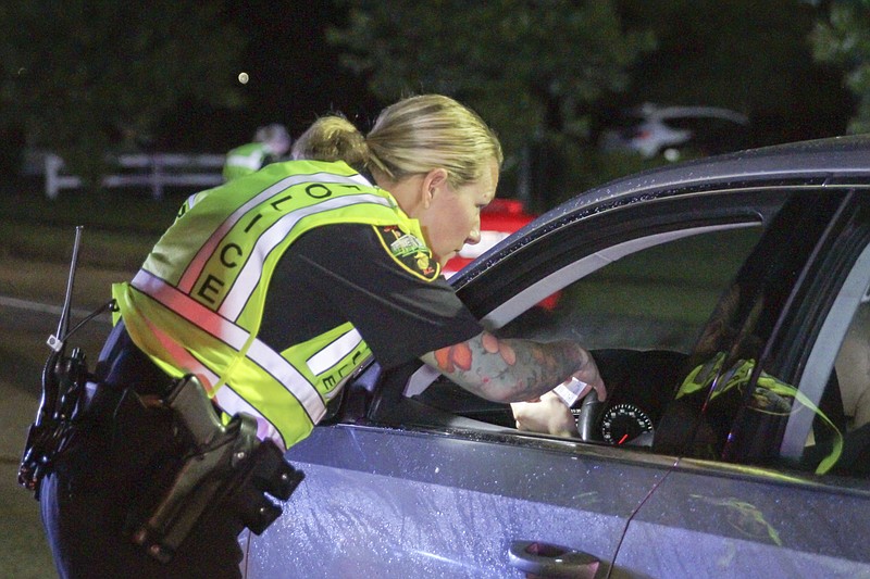 In this Friday, May 20, 2016 photo, Officer Teresa Orr with the Jacksonville Police Department speaks with a driver at a checkpoint in Jacksonville, N.C. Efforts to prevent deadly encounters between police officers and motorists, young, black males in particular, have lawmakers across the country considering changes to driver's education classes as a way to show teenagers how to react when stopped (Tina Brooks/The Jacksonville Daily News via AP, File)